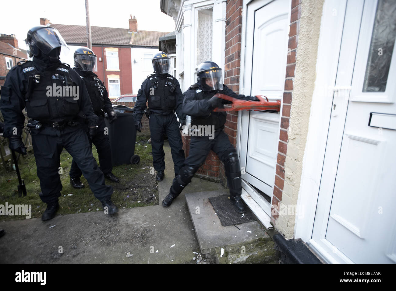 Ufficiali dal quartiere Bransholme Policing Team utilizzano un ariete per immettere una proprietà per la ricerca di farmaci, Hull, Regno Unito Foto Stock