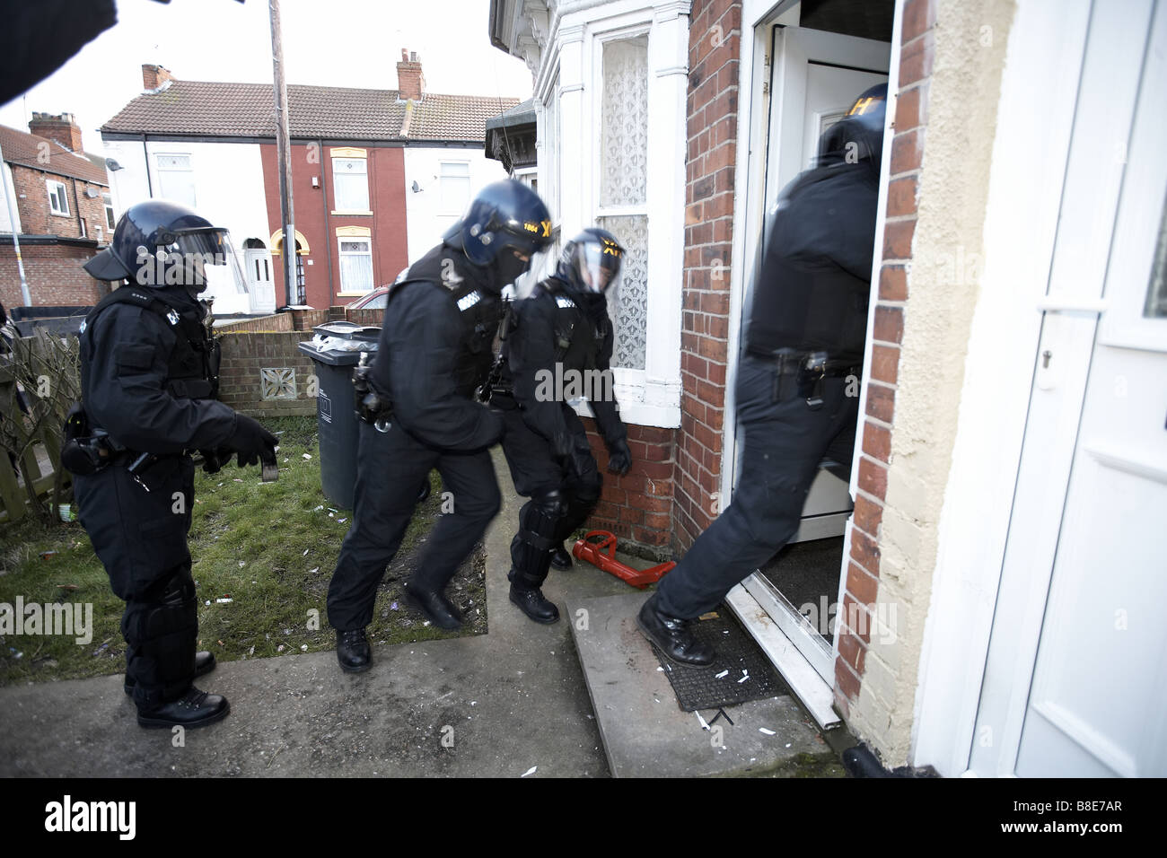 Ufficiali dal quartiere Bransholme Policing Team utilizzano un ariete per immettere una proprietà per la ricerca di farmaci, Hull, Regno Unito Foto Stock