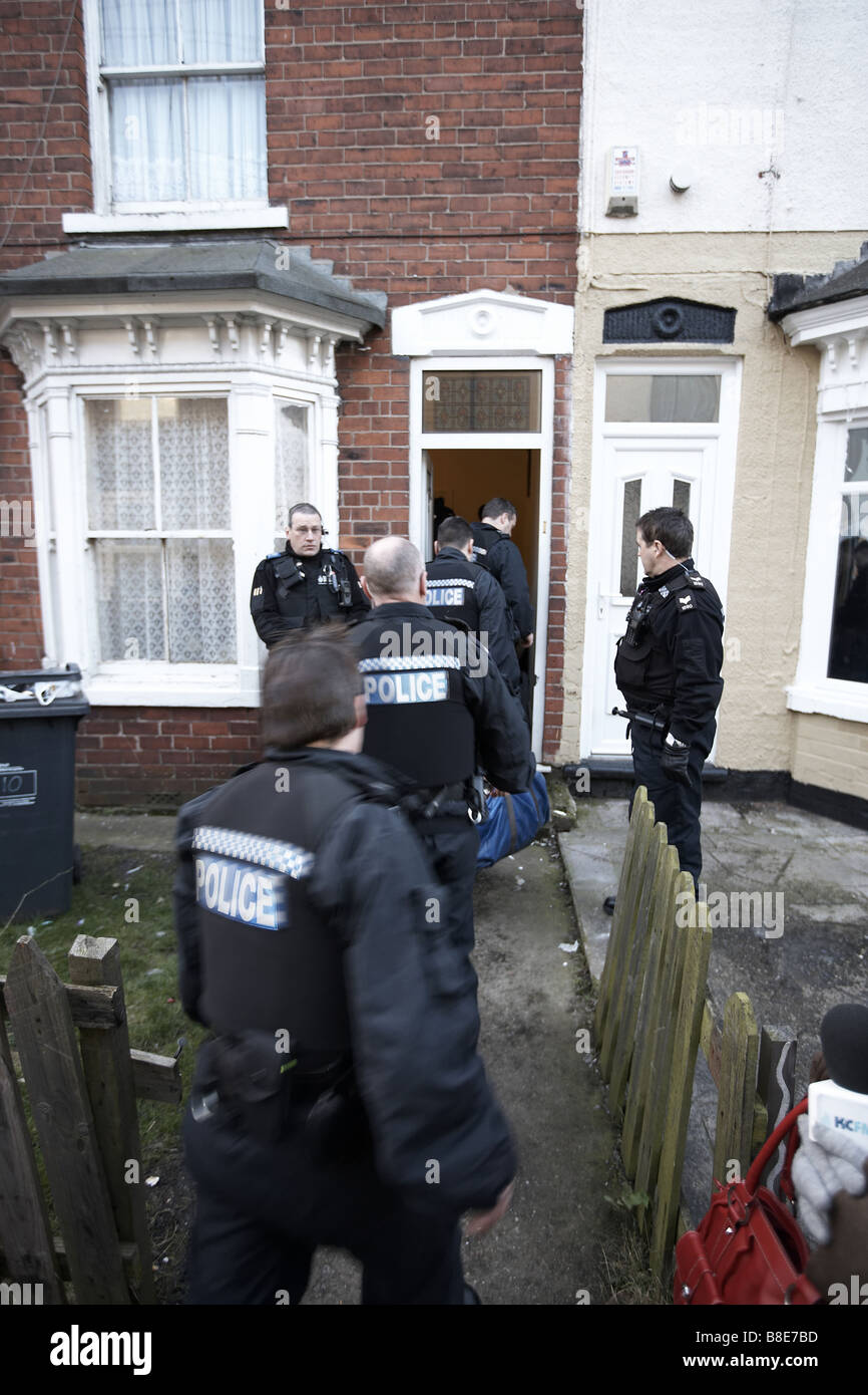 Ufficiali dal quartiere Bransholme Policing Team Immettere una proprietà durante una droga raid, Hull, East Yorkshire. Foto Stock