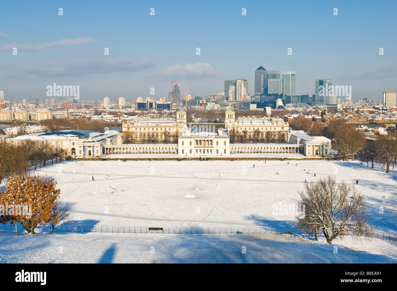 La vista dalla cima della collina di Greenwich Park si affaccia Marittime Greenwich e Canary Wharf con neve sul terreno. Foto Stock