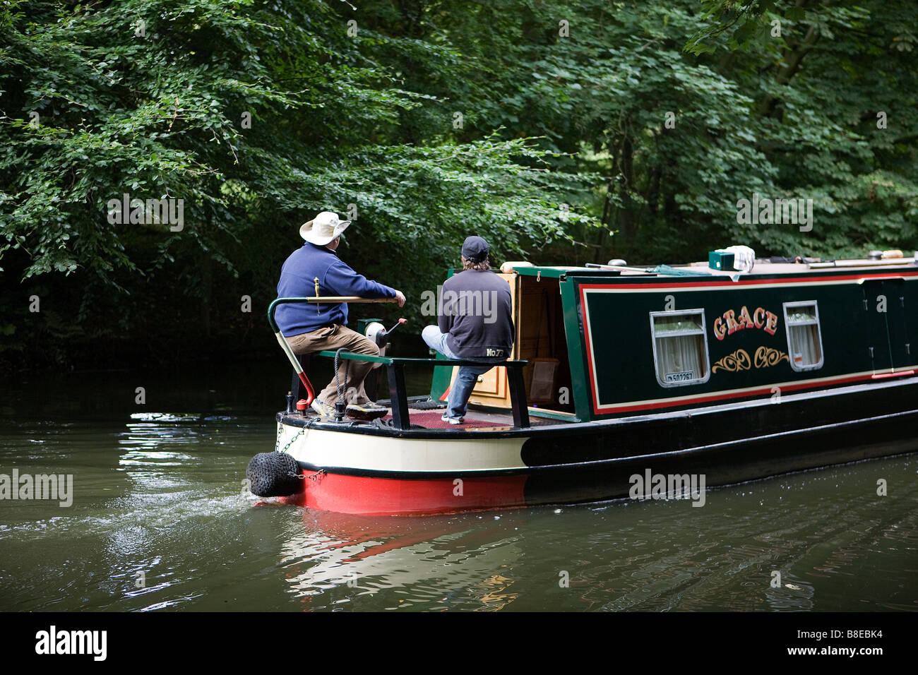 Due uomini sterzare una stretta barca lungo la Bridgewater Canal Foto Stock