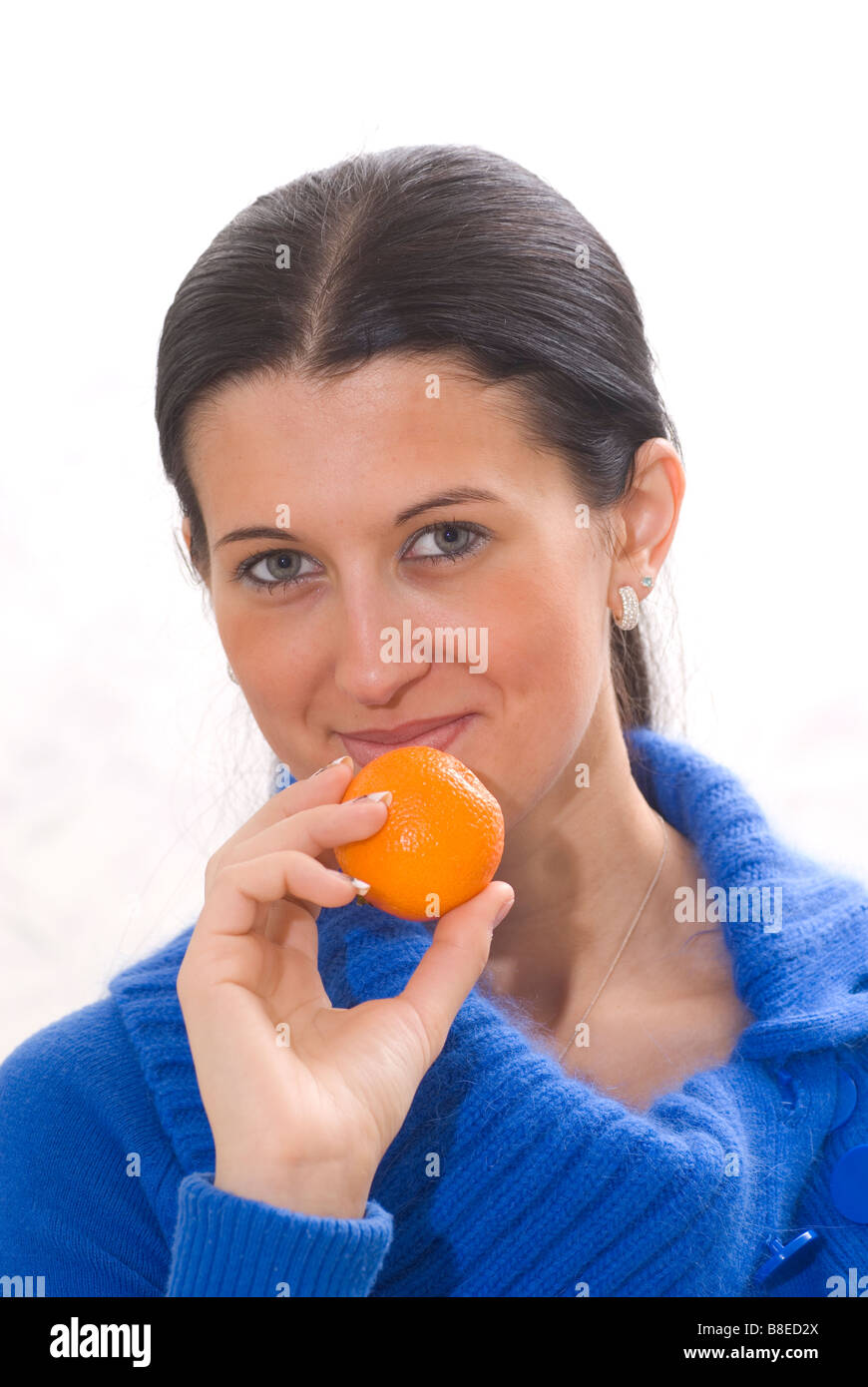 Bella giovane donna tenendo un mandarino frutto Foto Stock