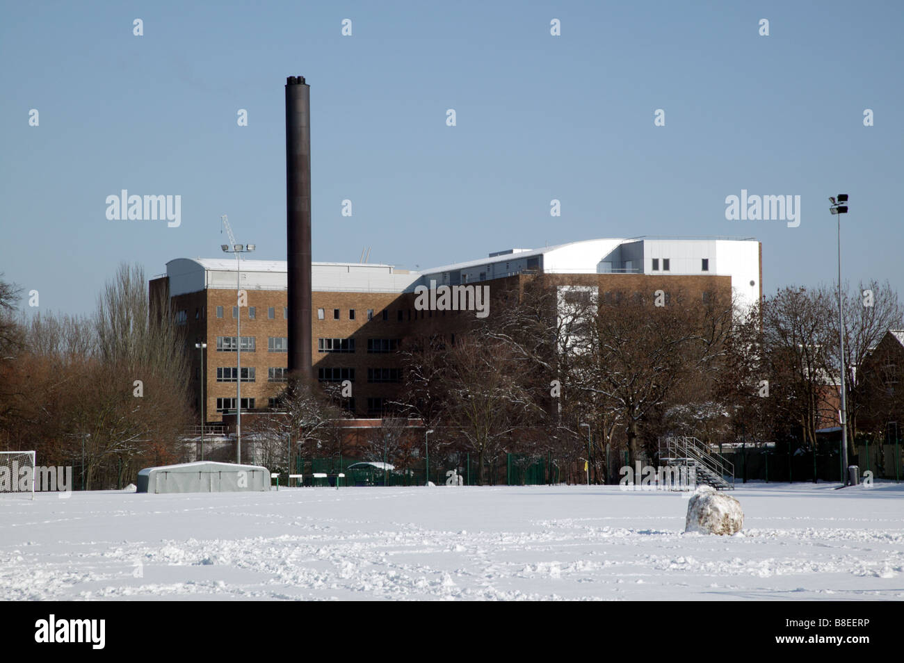 Inquadratura del retro della University Hospital Lewisham, preso dall'interno dell'Arena Ladywell athltics via su un inverni nevosi giorno Foto Stock