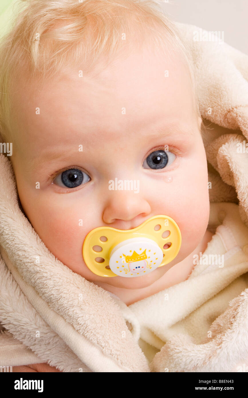 Lacrimoso allattamento baby 7 mesi con il manichino di colore giallo Foto Stock
