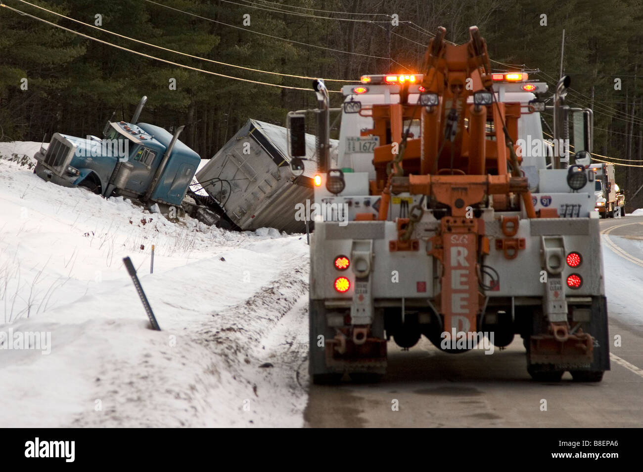 Un carrello di traino arriva sulla scena di un incidente di camion. Foto Stock