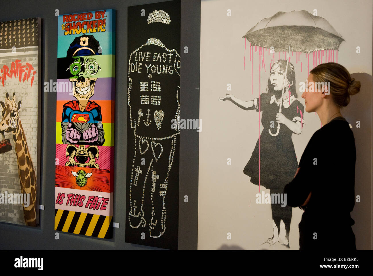 Nola Rosa, che mostra una ragazza essendo irrorata sotto un ombrello e altre opere di Banksy parte di Bonhams auction house di arte urbana Foto Stock