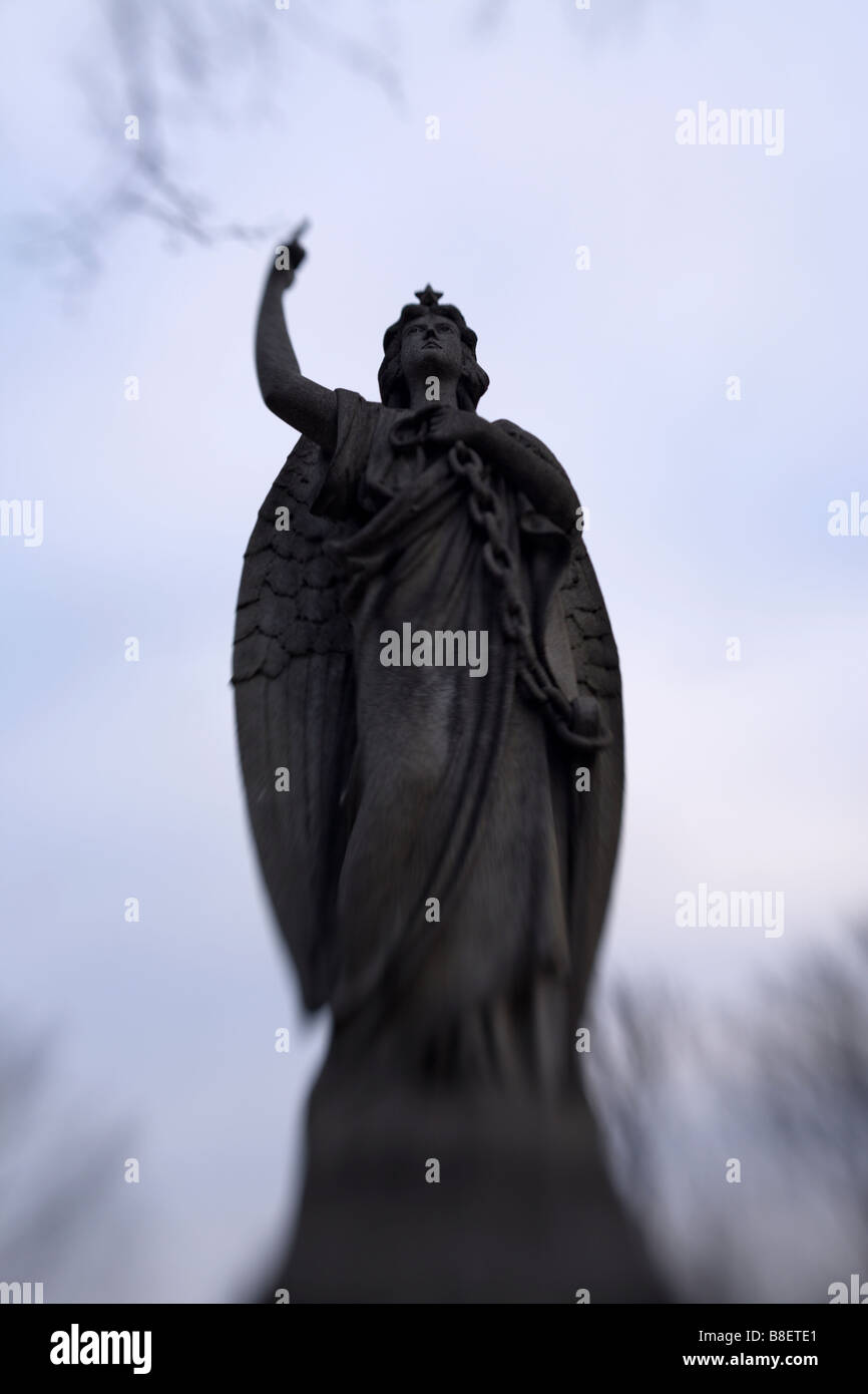 Una statua di un angelo ispiratore di un cimitero Foto Stock