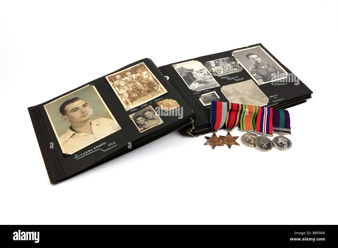 Un WW2 veterano s album di foto con un gruppo di medaglie contro uno sfondo bianco Foto Stock