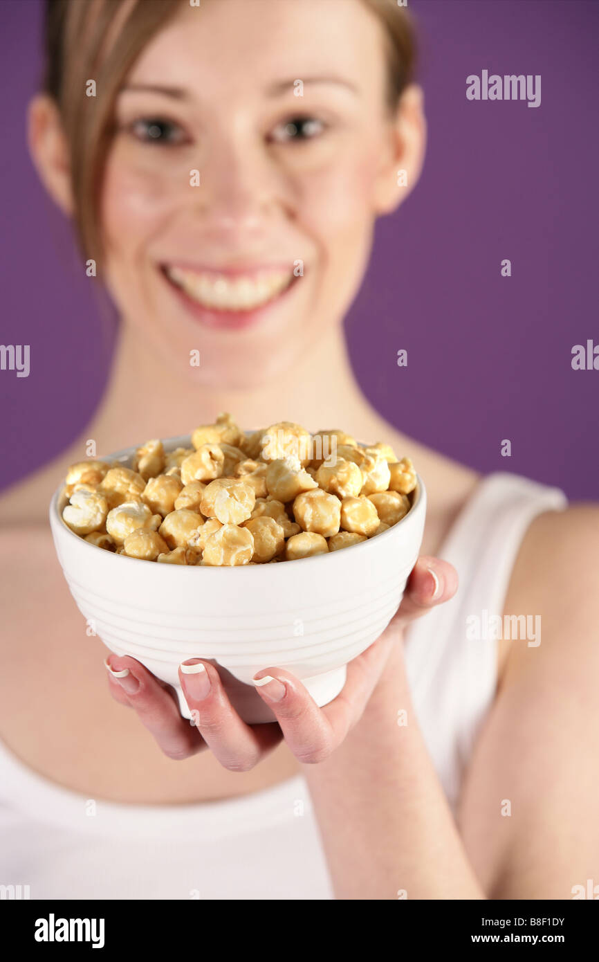 Ragazza con una ciotola di popcorn Butterkist Foto Stock