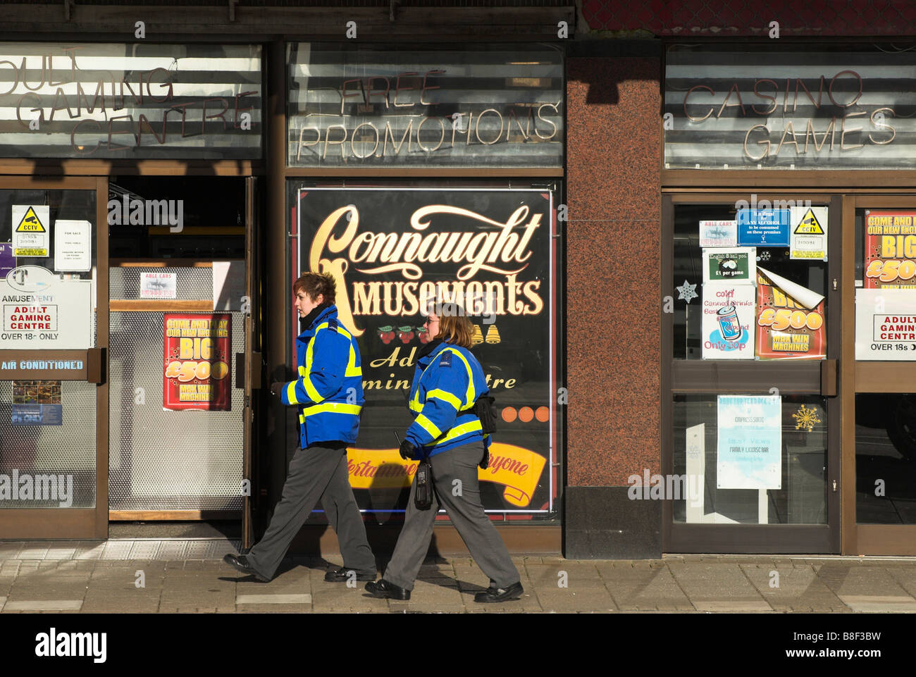 Il traffico di due operai / parcheggio operatori passano da una sala giochi sul lungomare a Worthing in West Sussex. Foto Stock