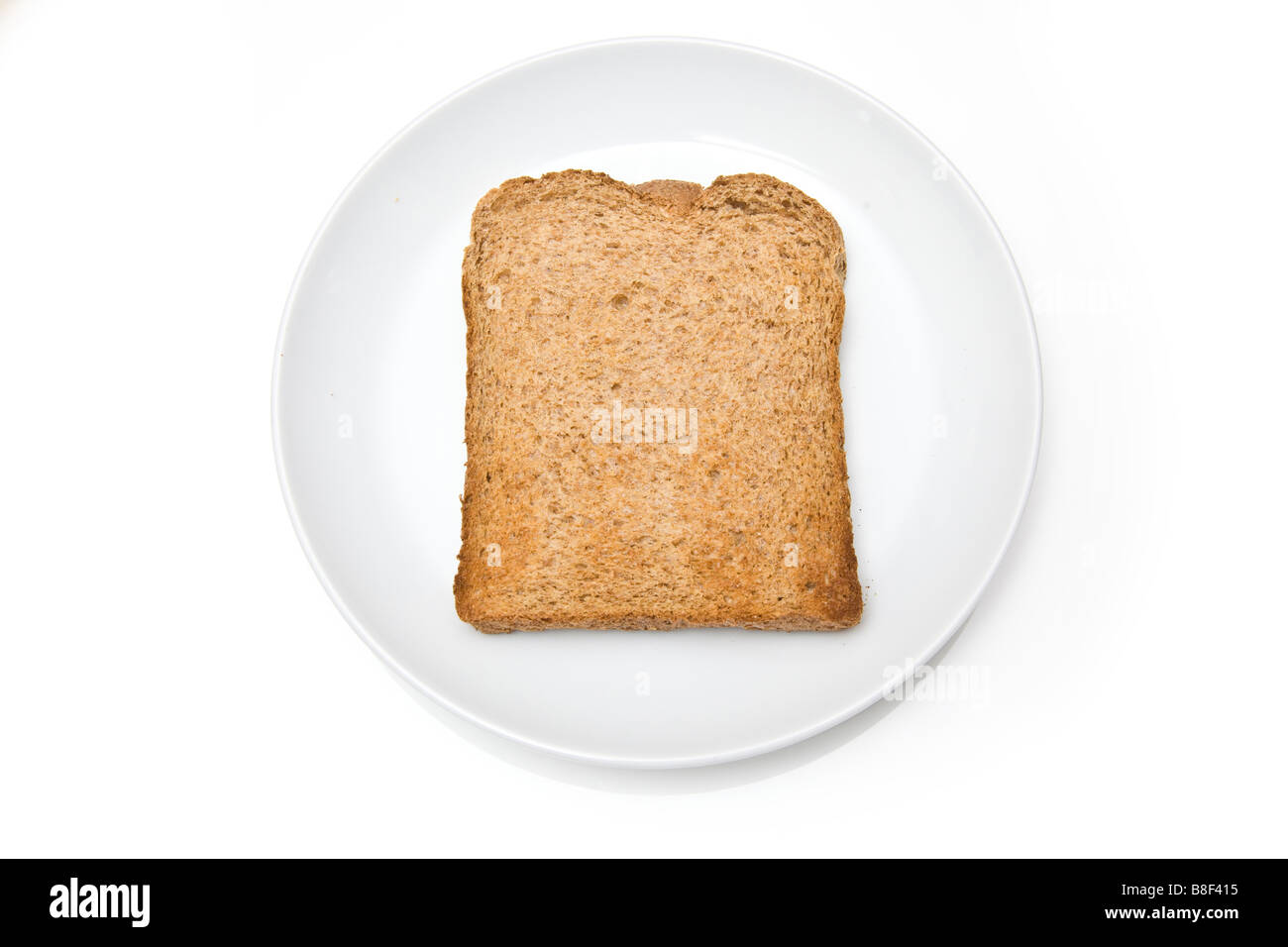 Fetta di pane tostato integrale su una piastra bianca. Foto Stock