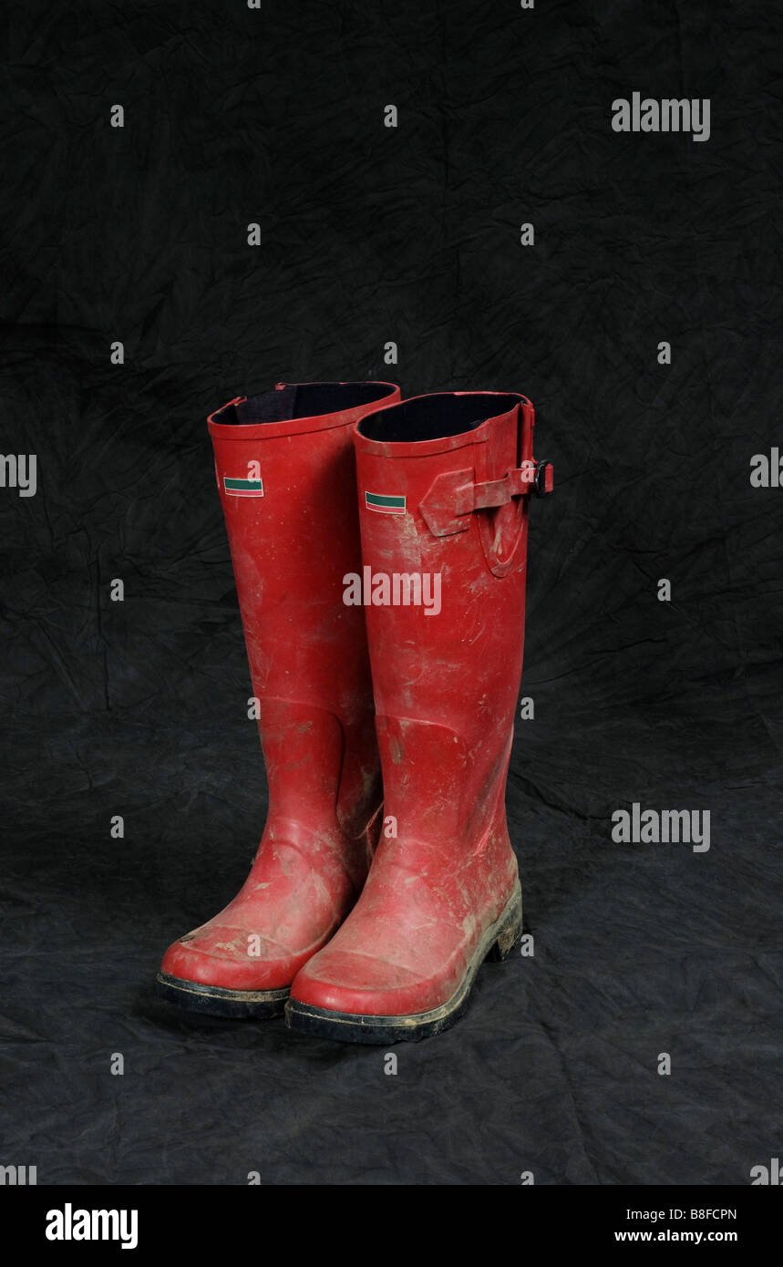 Wellingtons sporca in uno sfondo per studio Foto Stock