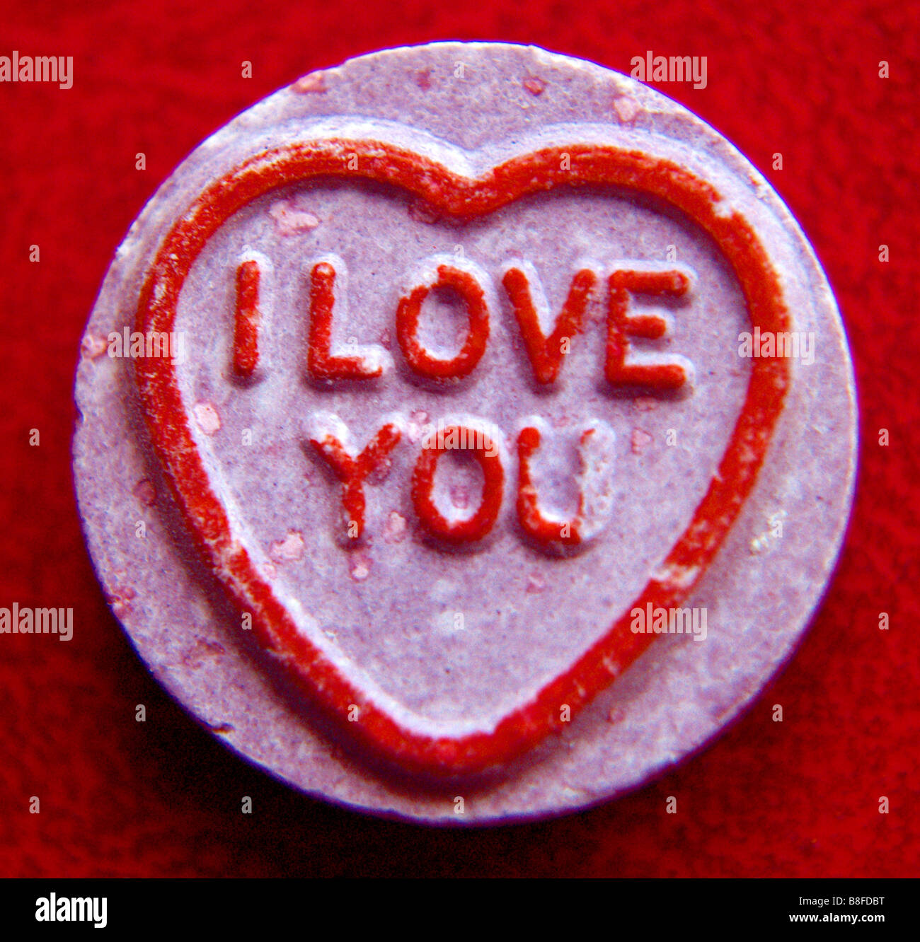 Close up di un amore cuore contro uno sfondo di colore rosso. "Ti Amo" Foto Stock