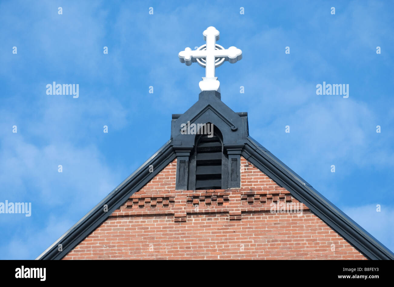 Croce in cima al punto di una chiesa Foto Stock