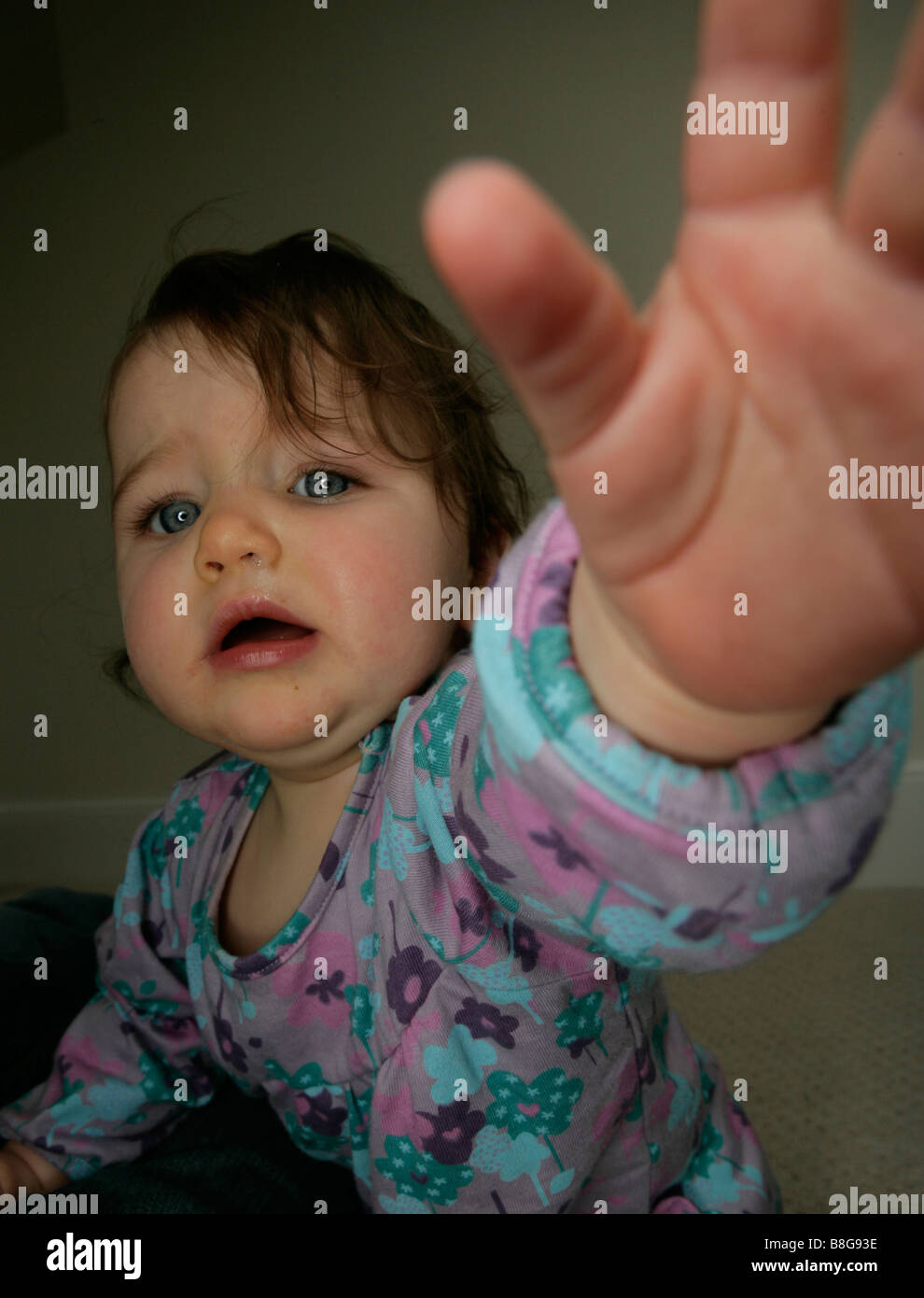 Un bambino raggiunge fuori di afferrare qualcosa Foto Stock