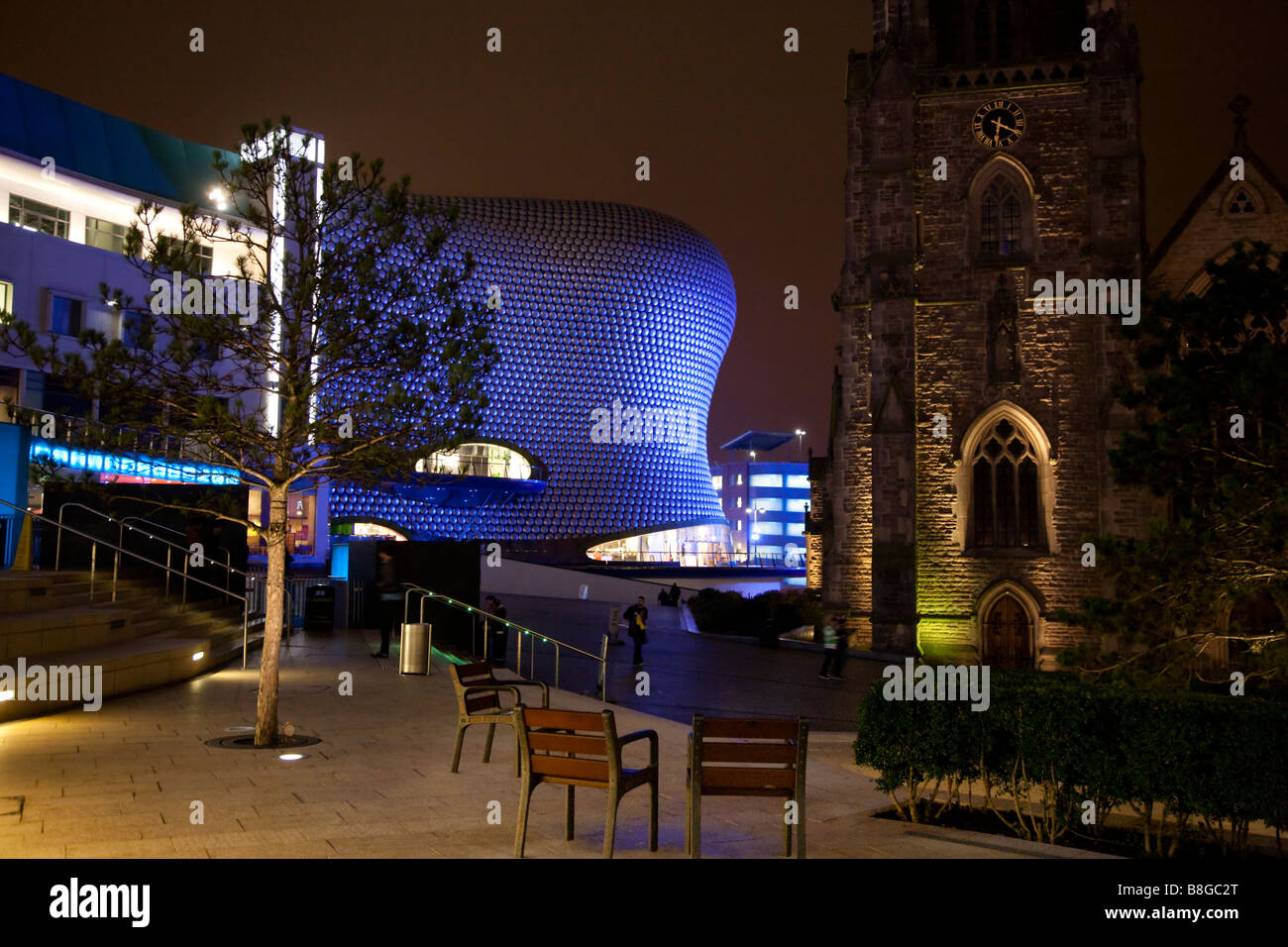 L'architettura di dal grande magazzino Selfridges contrasta con il St Martins chiesa Birmingham Inghilterra durante la notte Foto Stock