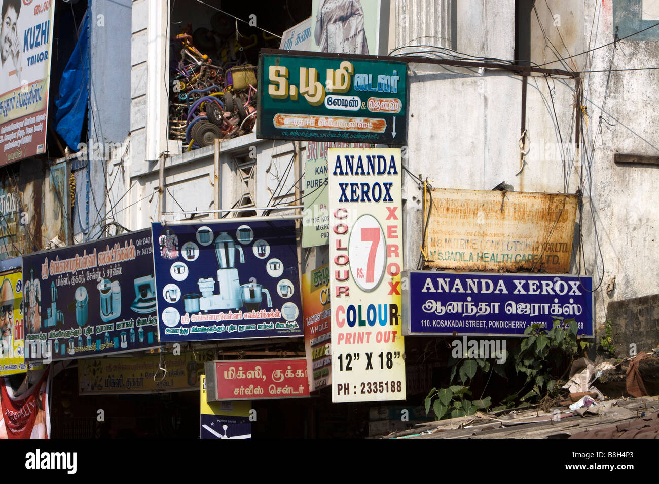 India Pondicherry Kosakadai Street di conglomerazione di coloratissimi cartelli pubblicitari Foto Stock