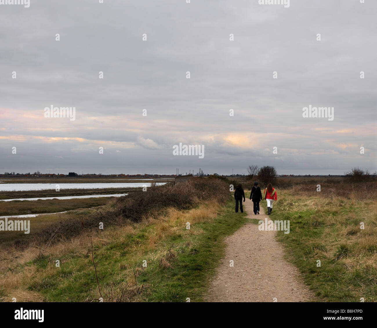 Tre persone a piedi lungo un percorso su due Tree Island in Essex. Foto Stock