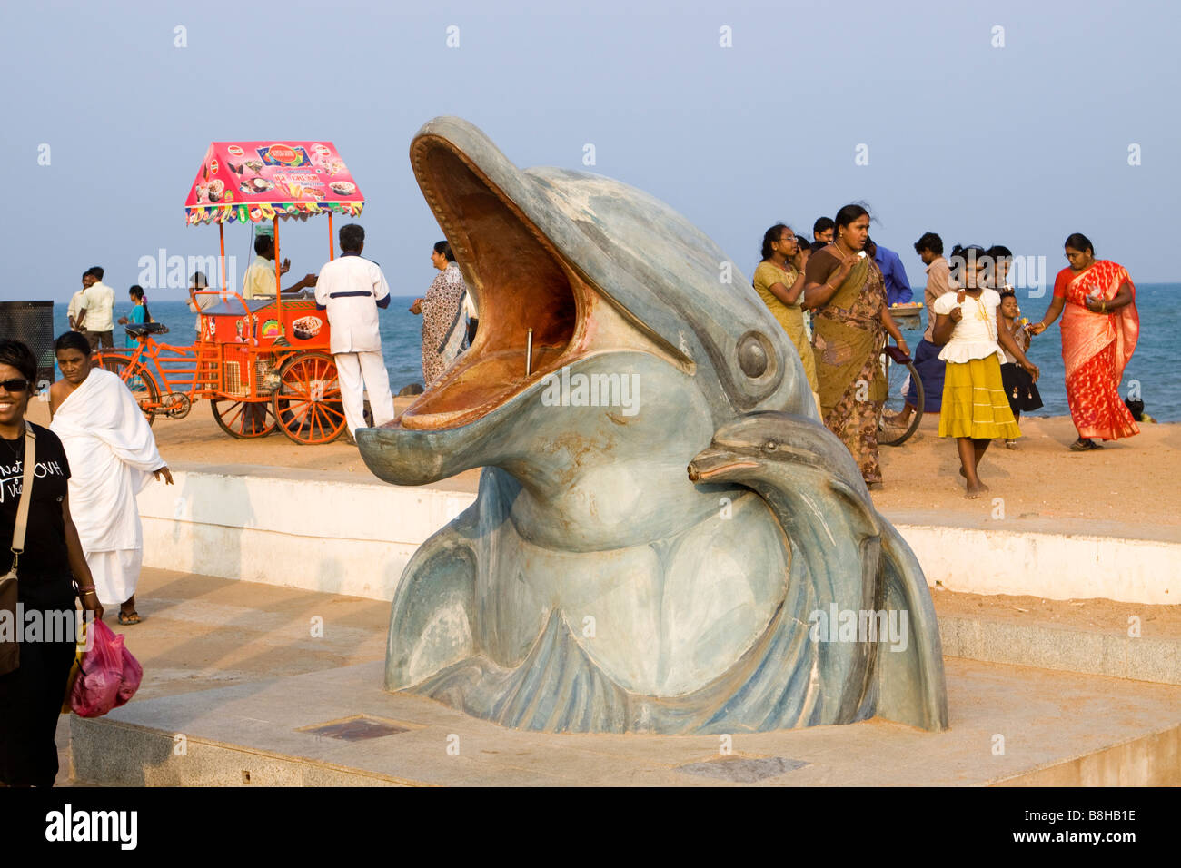 India Pondicherry turisti indiano rilassante sul lungomare nel tardo pomeriggio presso la fontana dei Delfini Foto Stock