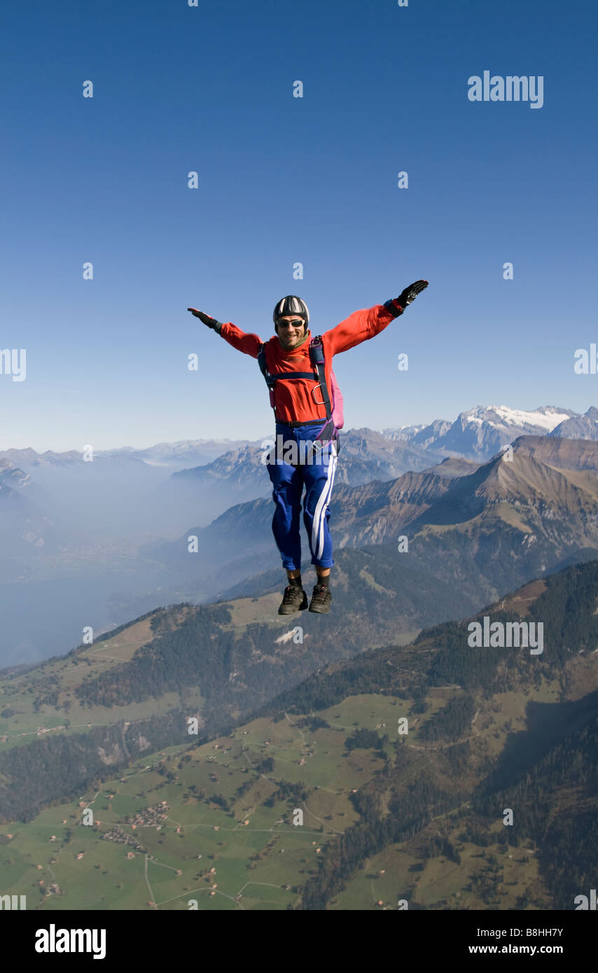 Paracadutista è sedersi volare nel cielo sopra il bellissimo scenario di montagna. Il divertimento subacqueo è freefly e divertirsi nel cielo blu. Foto Stock