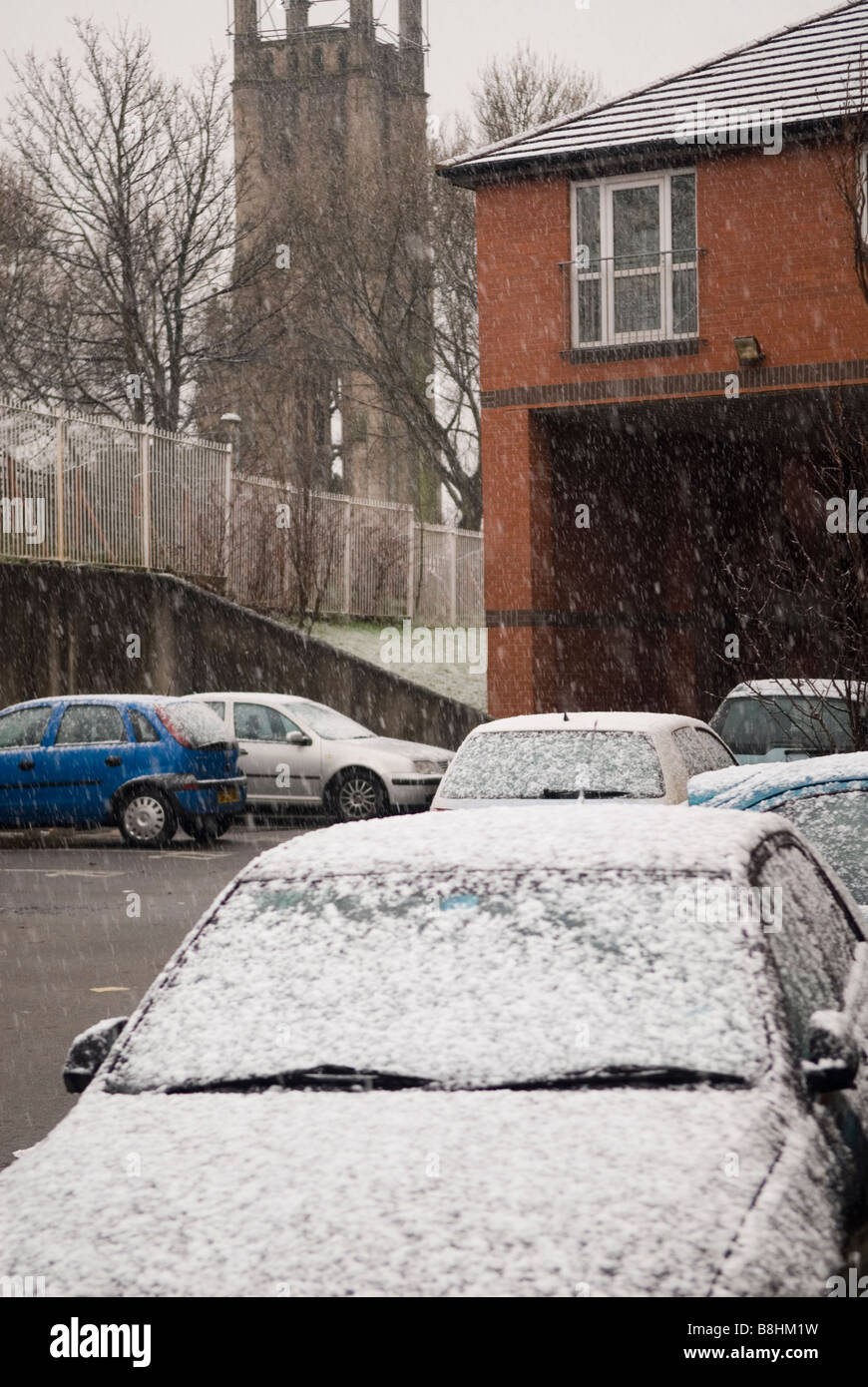 Auto coperti di neve in un parco auto Manchester REGNO UNITO Foto Stock