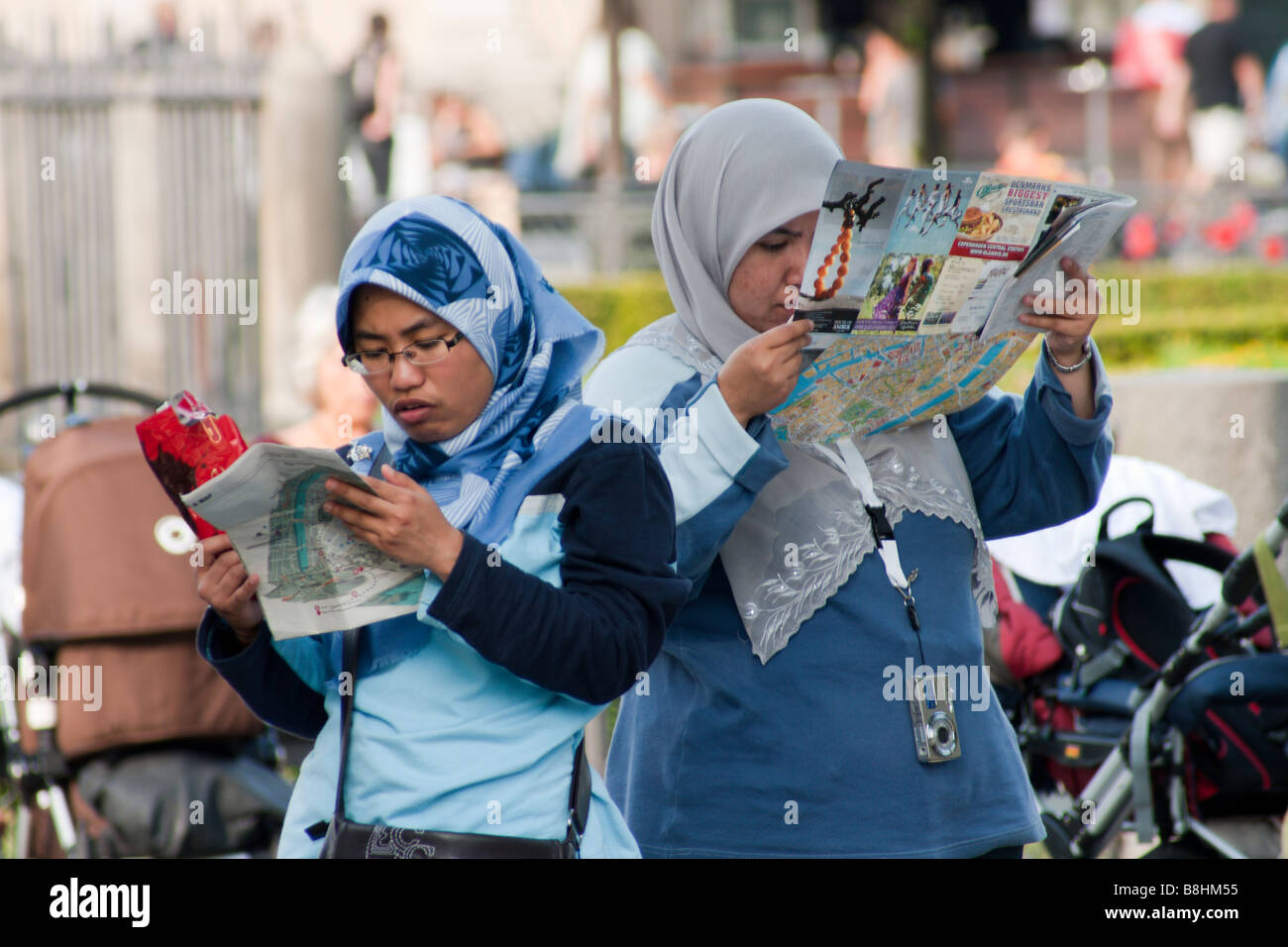 Due femmina turisti musulmani guardando le mappe della città di Copenaghen, Danimarca Foto Stock