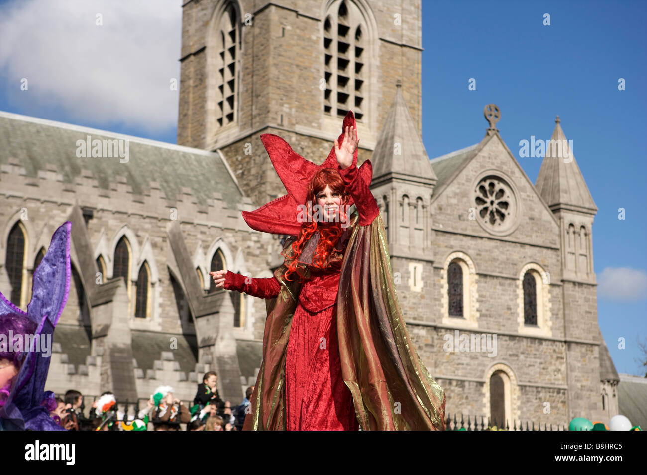 Un partecipante onde per la folla di il giorno di San Patrizio parata in Dublino Irlanda Foto Stock