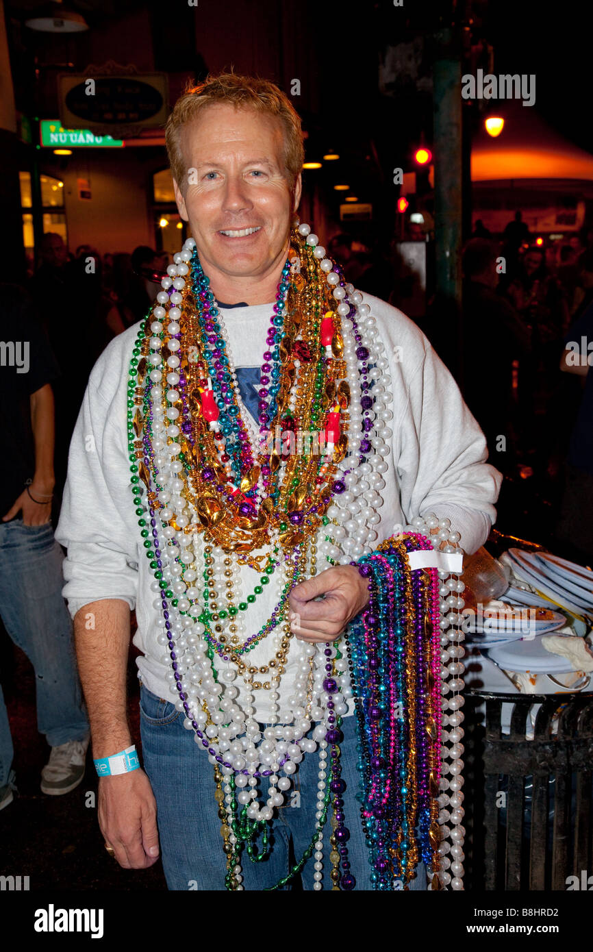 Uomo che indossa e tenendo premuto molte collane di perle, Mardi Gras  celebrazione e sfilata Foto stock - Alamy