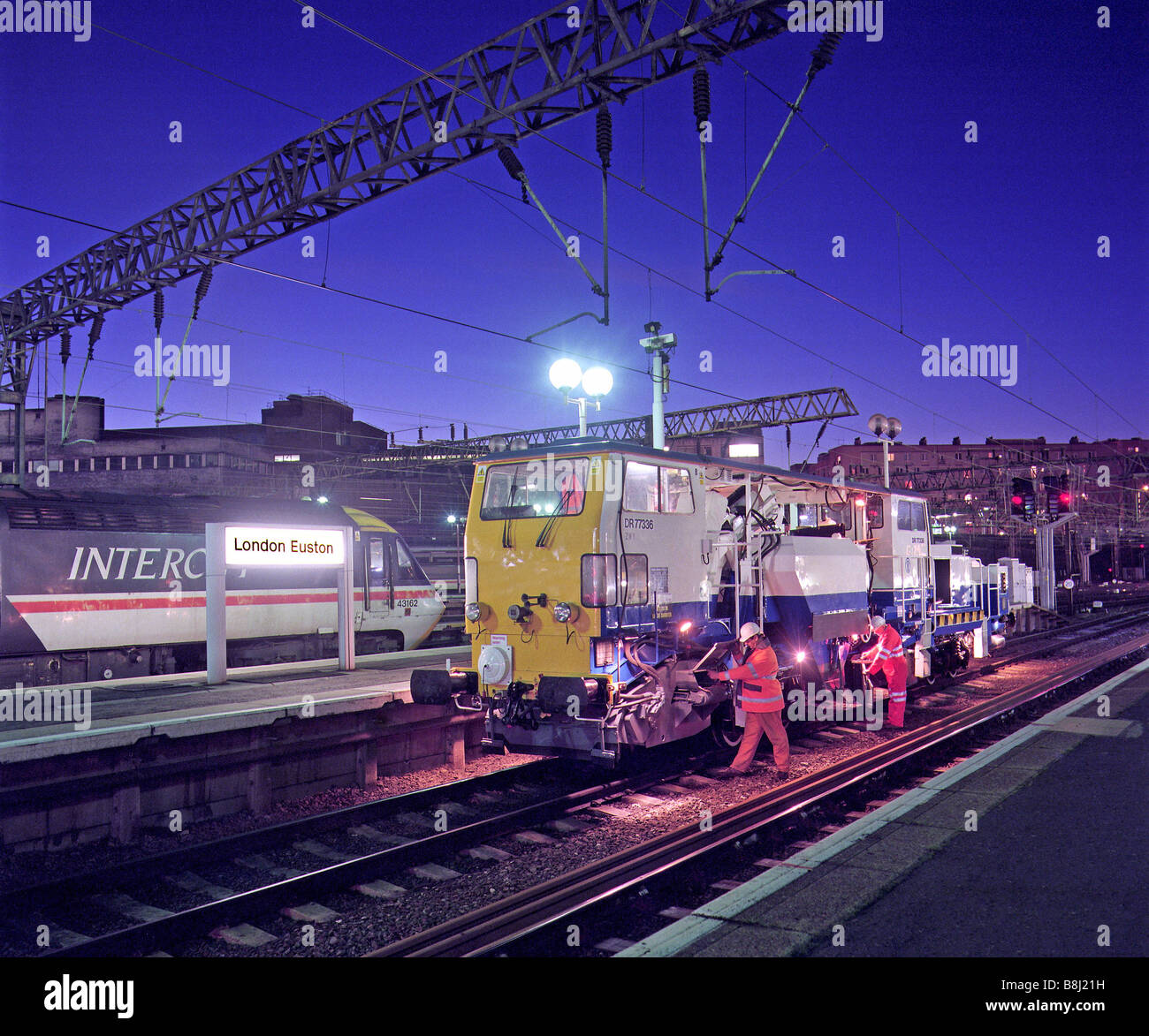 I contraenti preparare una zavorra macchina compattatrice per la notte a lavorare sulla nuova pista installato nel corso di un programma di aggiornamento. Foto Stock