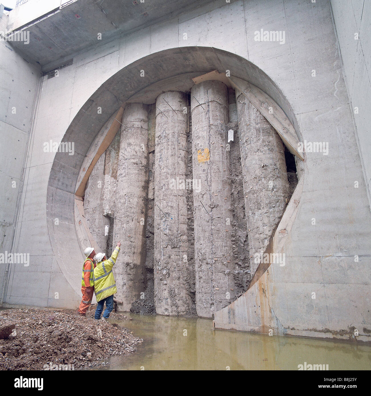Esposti pali di fondazione visibili nel portale di una strada sterrata tunnel. Queste pile sarà rimossa per completare la struttura Foto Stock
