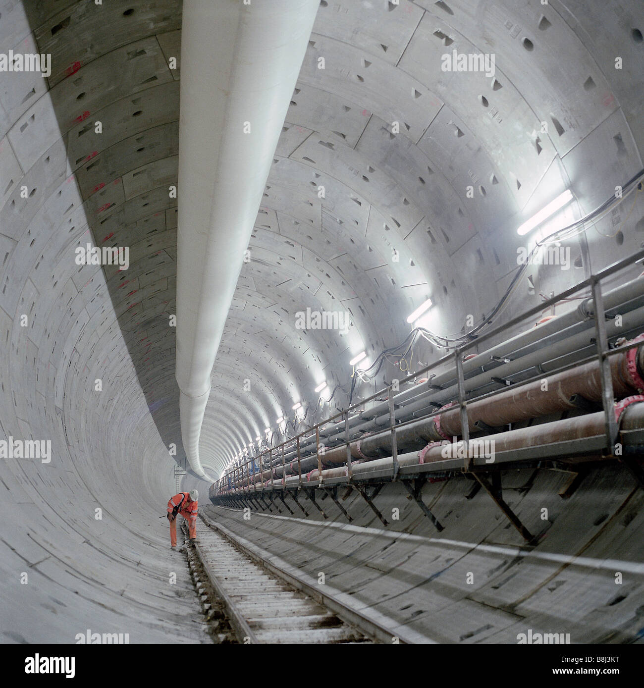 Ingegnere esamina la sezione delle opere via in un completato e rivestita la sezione del Tamigi Tunnel sul collegamento ferroviario del tunnel della Manica. Foto Stock