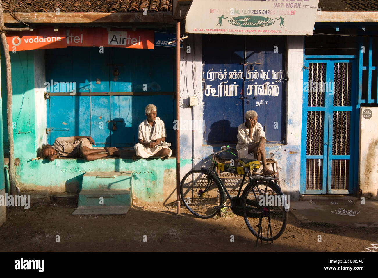 India Tamil Nadu Kumbakonam uomini rilassante in inizio di mattina di sole prima di negozi aperti Foto Stock