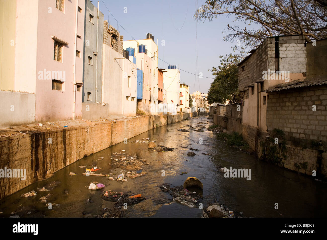 Un open drain tempesta a Bangalore in India. Il pozzetto di scarico è disseminato di spazzatura e odora di un tombino aperto. Foto Stock