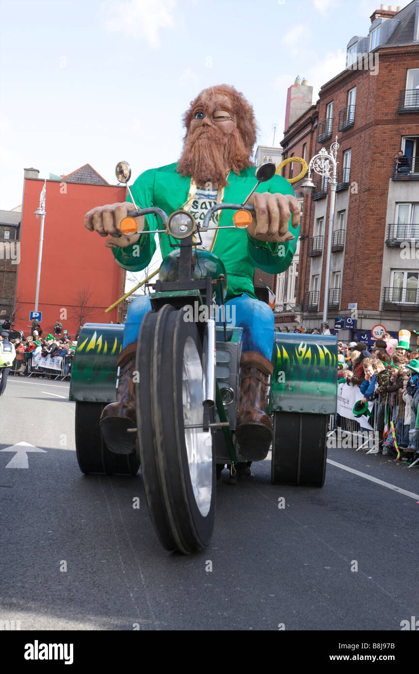 Un grande fantoccio di St Patrick corse a tre ruote moto nel il giorno di San Patrizio parata in Dublino Irlanda Foto Stock