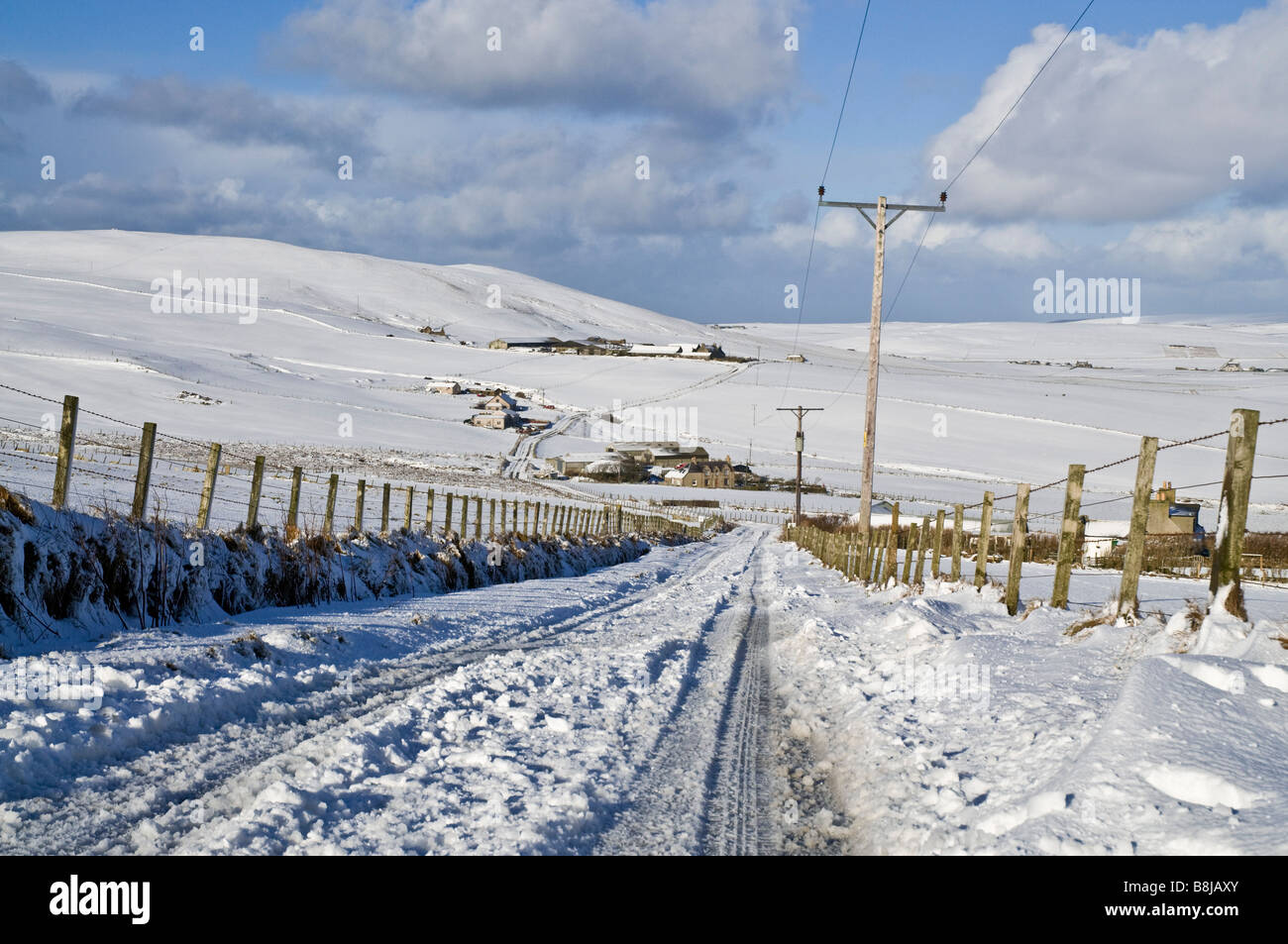 dh ROADS UK Icy nevoso strada campi di neve Agriturismi idro pali elettrici Orkney Countrylane wintertime corsia paese invernale Scozia rurale Foto Stock