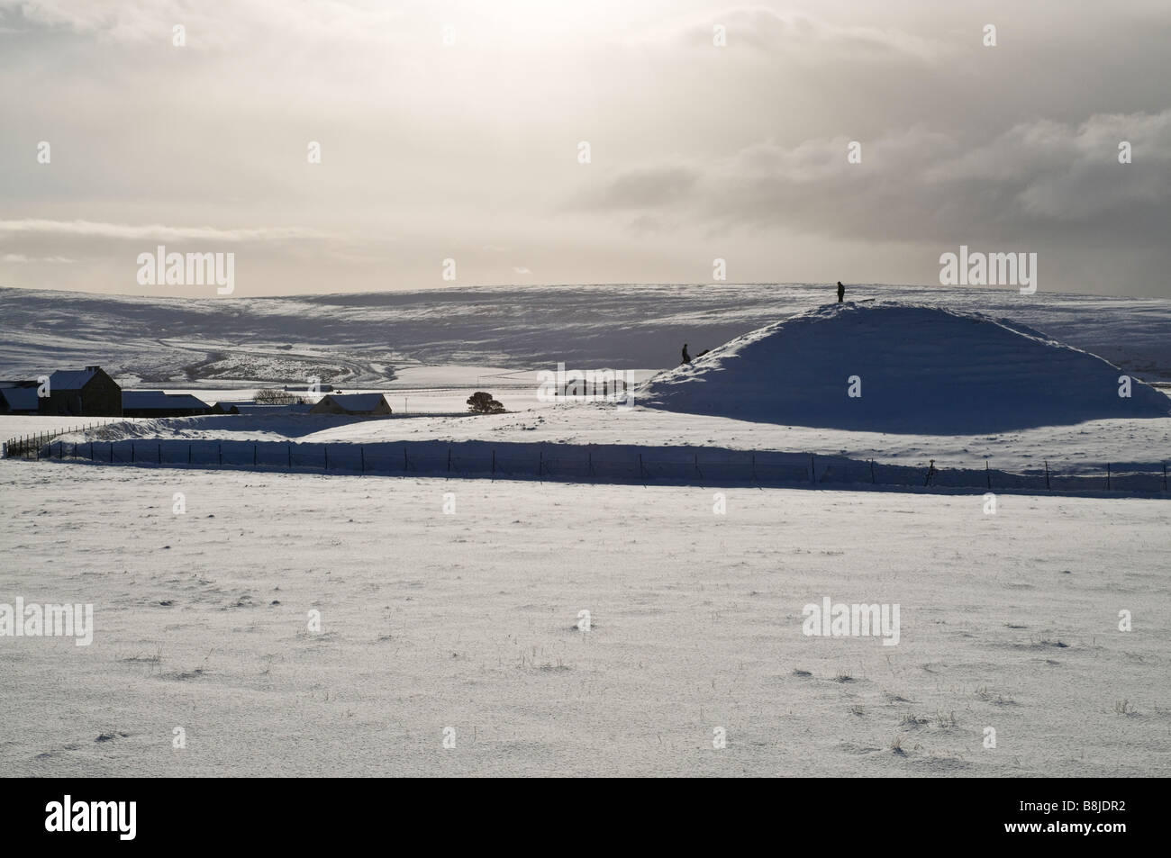 Dh MAESHOWE Isole Orcadi neolitiche di sepoltura camera tomba mound persone snowscape cairn persona Foto Stock