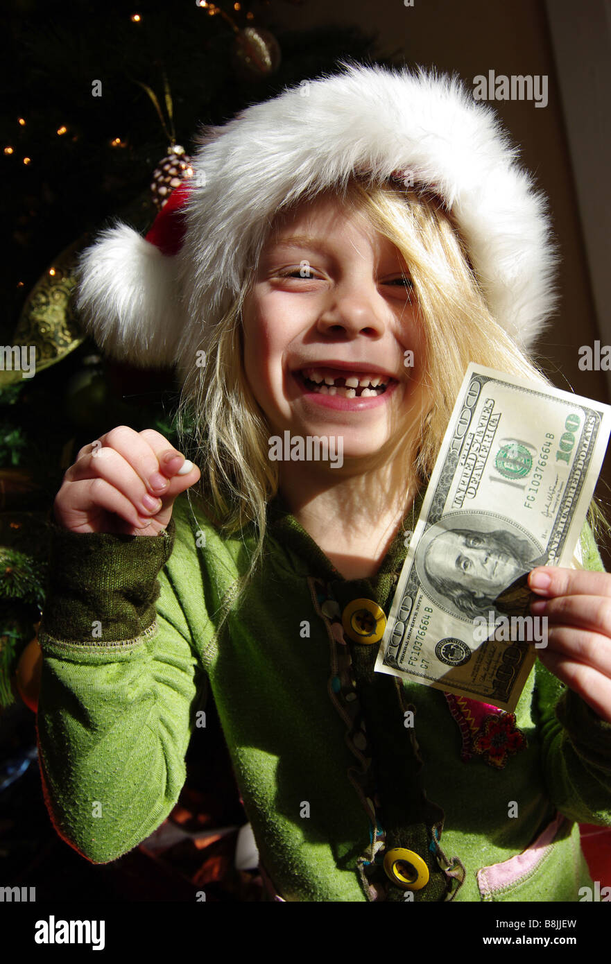 Una bambina diventa dono dal dente di fata il giorno di Natale per giocare e agitare con i suoi denti. Foto Stock