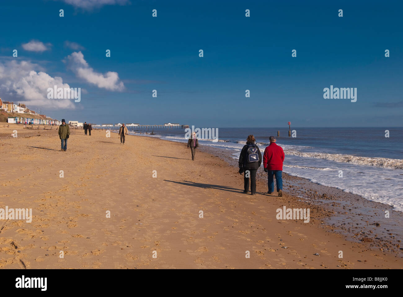 La gente camminare lungo Southwold Beach su un bel giorno Foto Stock