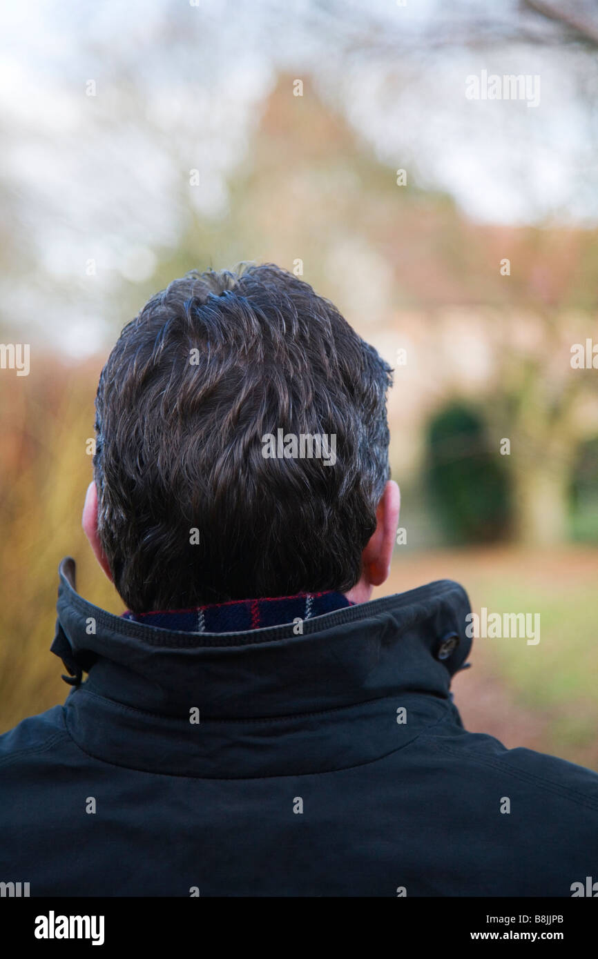 Un uomo maturo seduto in un cimitero. Foto Stock