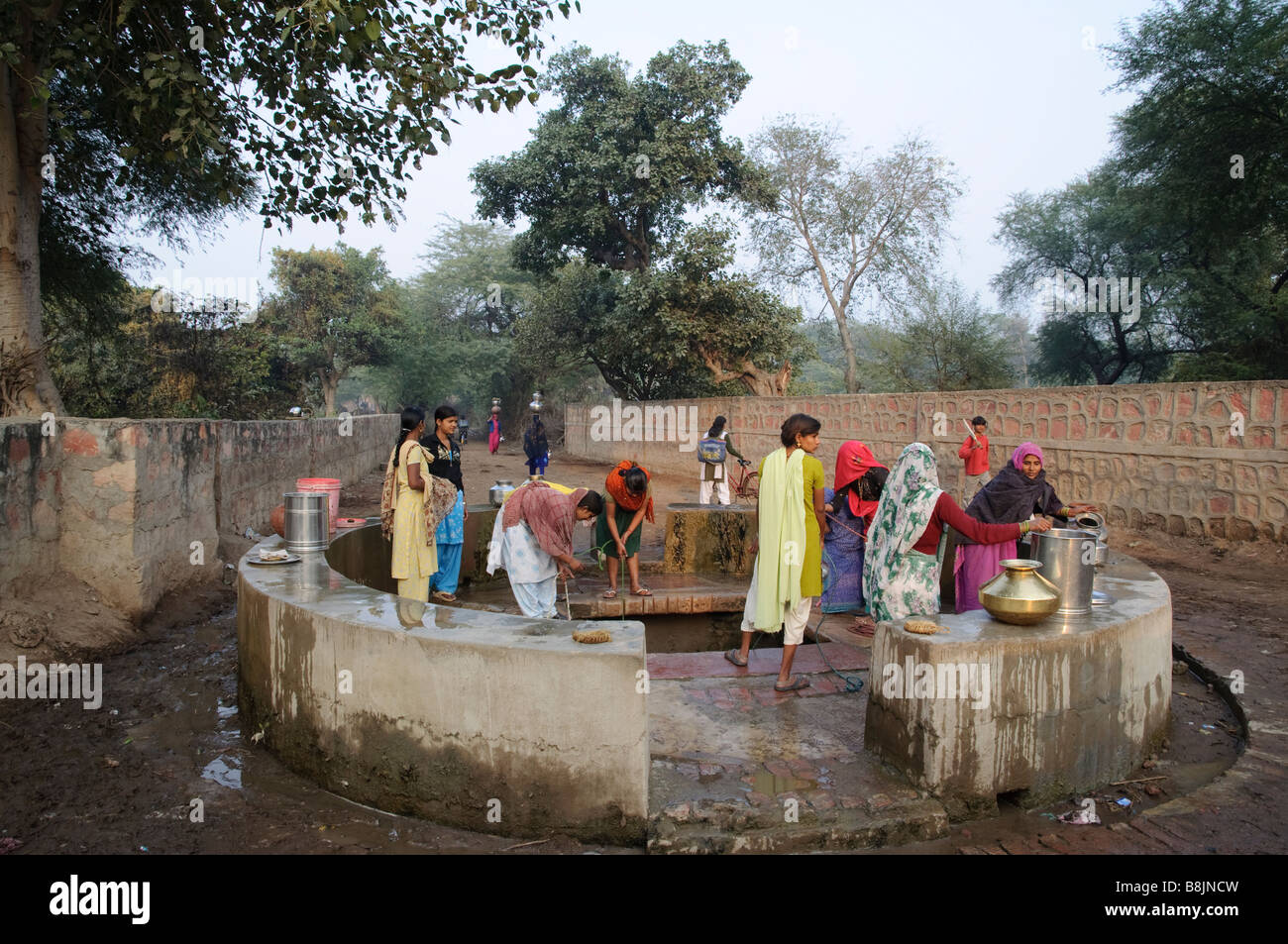 Le donne indiane prendendo l'acqua al pozzo del villaggio Bharatpur India Foto Stock