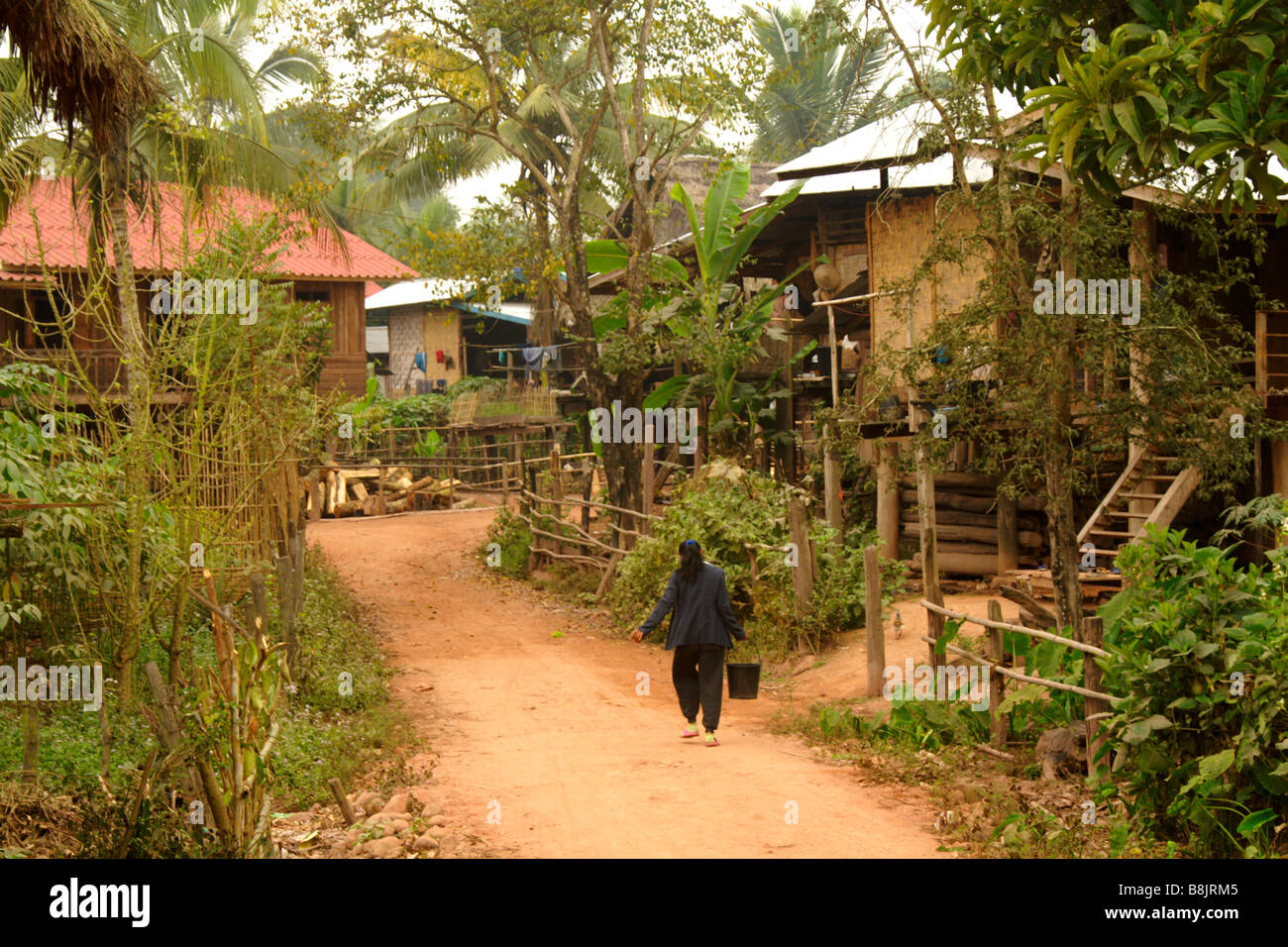 Donna che trasportano l'acqua, Nero Tai villaggio di Ban Nam Ngaen, Namtha Provincia, Laos Foto Stock