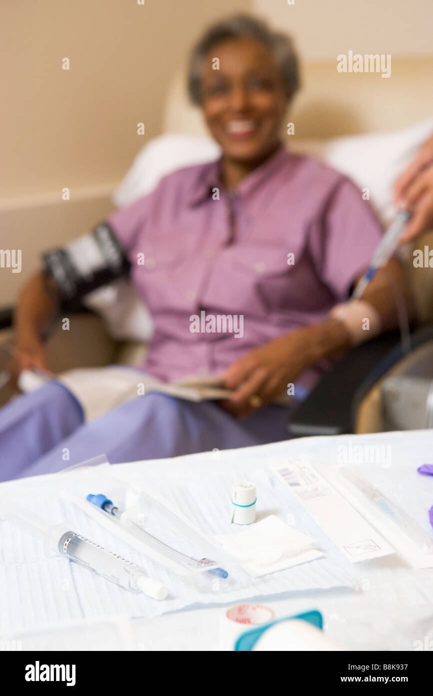 Apparecchiature mediche a una tabella con un paziente in background Foto Stock
