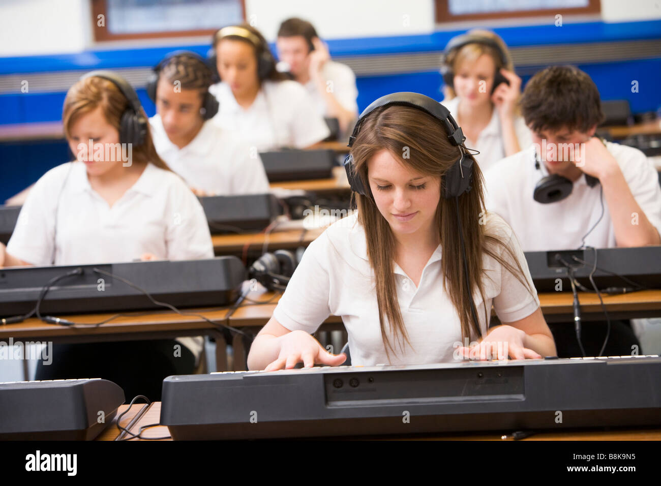 Gli studenti nella classe di musica lavorando sulle tastiere Foto Stock