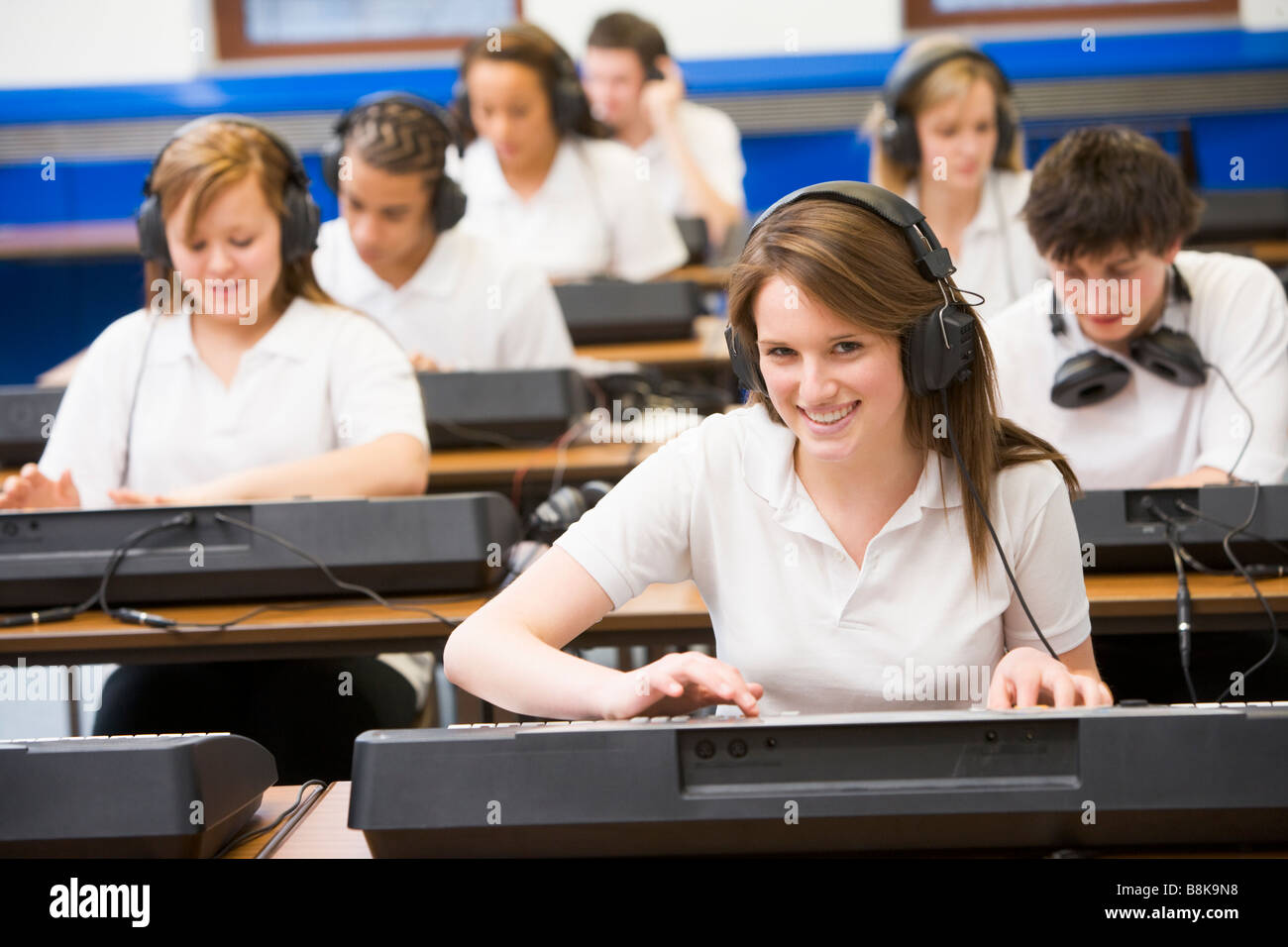 Gli studenti nella classe di musica lavorando sulle tastiere Foto Stock