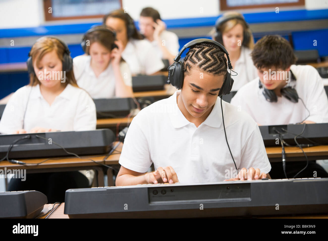 Gli studenti nella classe di musica lavorando sulle tastiere Foto Stock