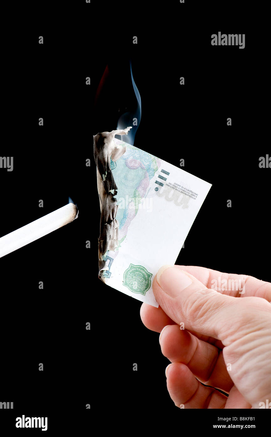 Oggetto sul nero valuta bruciando denaro cartaceo Foto Stock