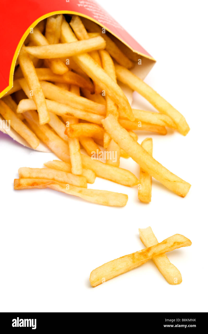 Malsana fast food. Le patatine fritte in caduta da inclinato di scatola di cartone, due pezzi che assomiglia ad una croce, sfondo bianco Foto Stock
