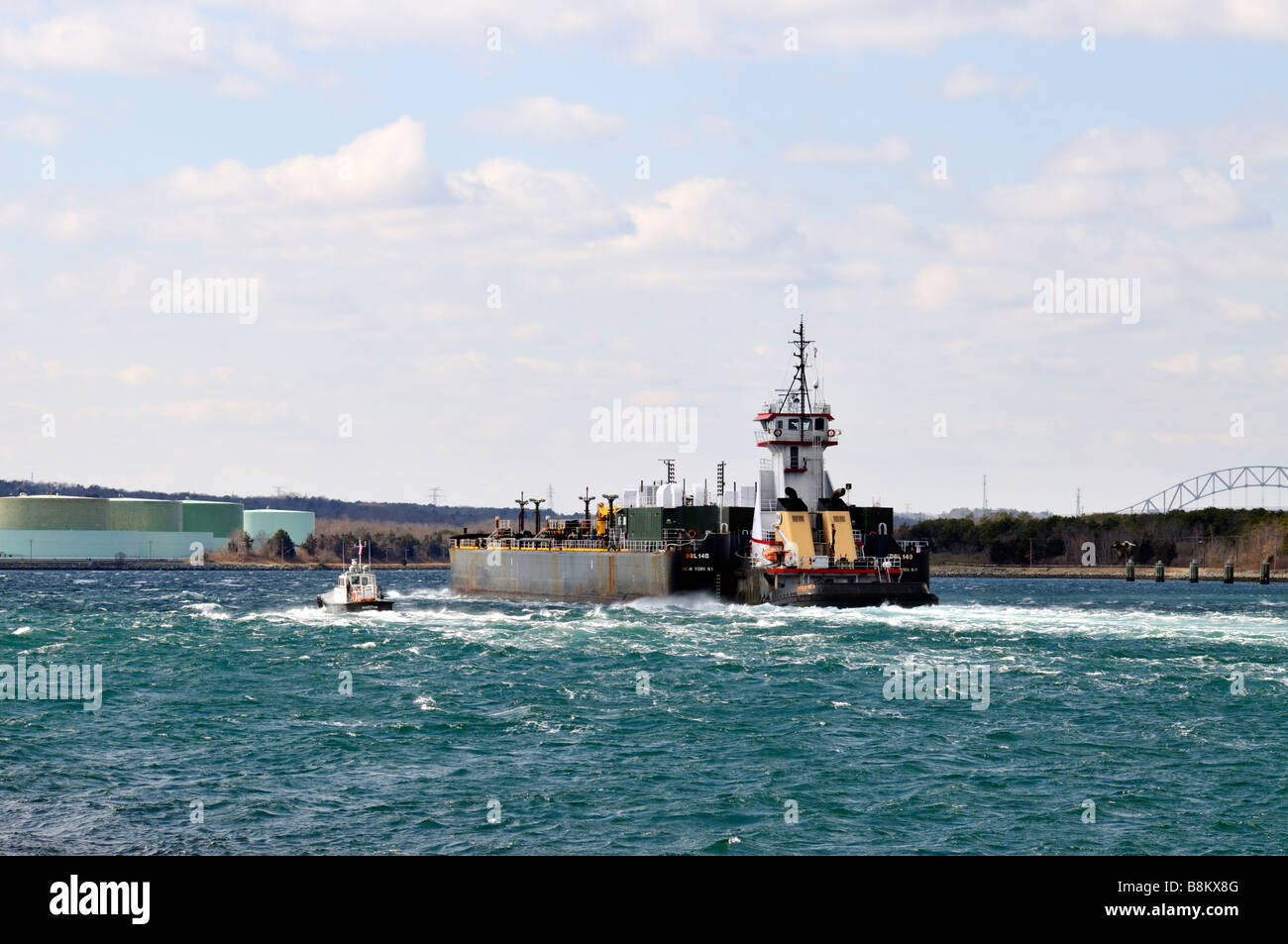 Rimorchiatore spinge [le petroliere a doppio scafo] olio combustibile passante chiatta " Cape Cod Canal' con barca pilota accanto al 'Mirant Centrale Elettrica Foto Stock