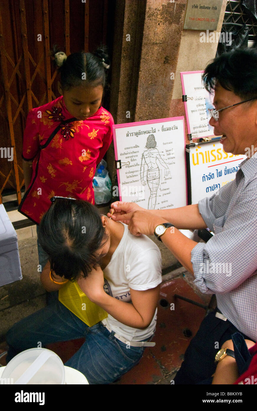 L'uomo la pratica di medicina tradizionale cinese in vicolo del mercato - Sampeng Lane Soi Wanit 1 in Chinatown centrale di Bangkok in Thailandia Foto Stock