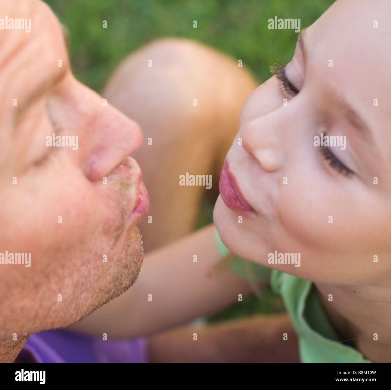 Otto anni girl circa a baciare il suo padre Foto Stock